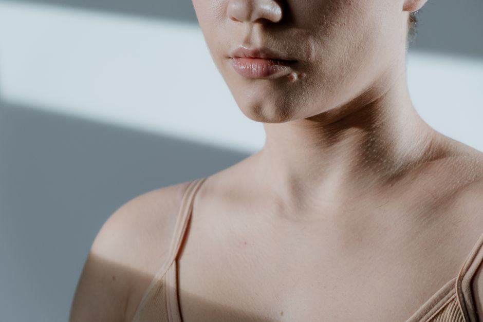 Close-up of a woman's face and shoulders in soft, natural lighting.