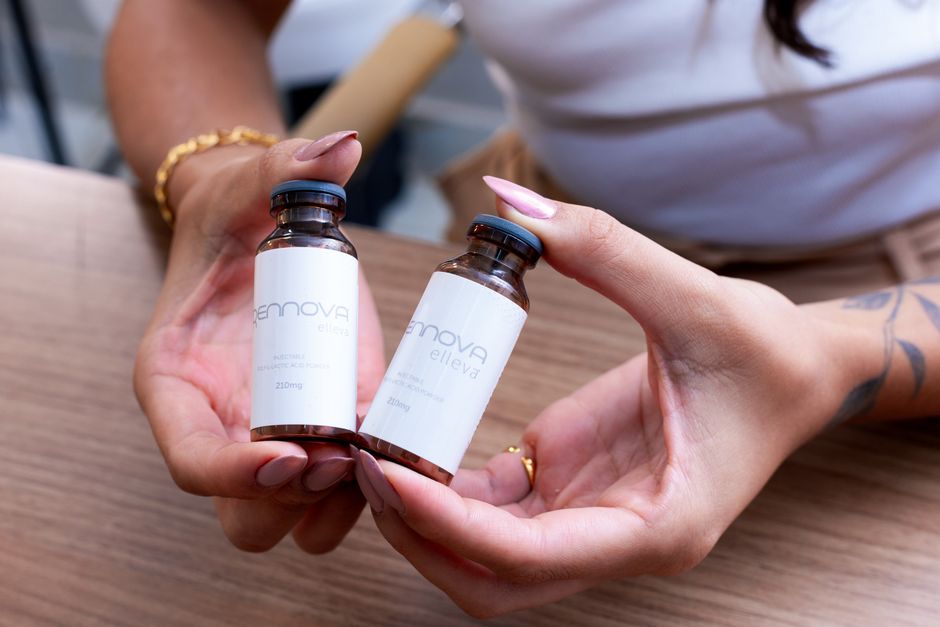 Hands holding cosmetic serum vials, focusing on branding and packaging detail.