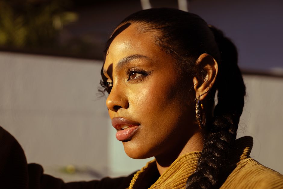 Close-up of a woman with braided hair, captured during sunset in São Paulo, Brasil.