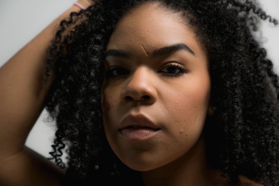 Close-up portrait of a beautiful woman with natural curly hair, showcasing confidence and grace.