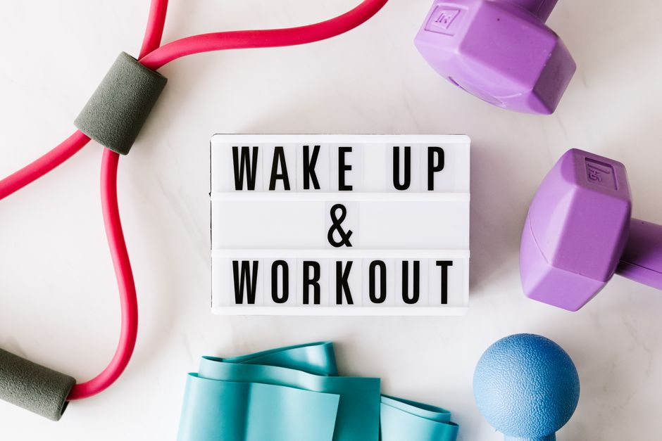 Top view closeup composition of wake up and workout inscription on light box surface among